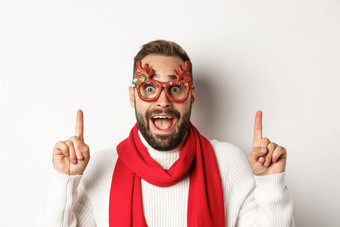 圣诞节一年庆祝活动概念特写镜头英俊的有胡子的男人。聚会，派对眼镜红色的围巾庆祝冬天假期指出手指复制空间