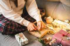 女人手包装圣诞节礼物盒子关闭裁剪女坐准备自然生态礼物沙发上装饰元素项目快乐圣诞节一年Diy包装概念
