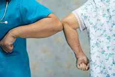 亚洲医生老病人撞肘部正常的社会距离避免科维德冠状病毒