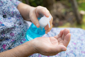 亚洲高级上了年纪的夫人女人病人洗手蓝色的酒精洗手液过来这里保护安全感染杀了科维德冠状病毒细菌细菌