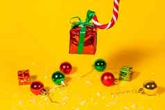 糖果狗棒棒糖持有礼物盒子圣诞节现在黄色的背景圣诞节糖果一年装饰