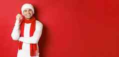 肖像快乐男人。享受圣诞节假期穿圣诞老人他围巾微笑快乐站红色的背景