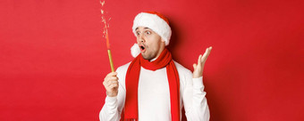 概念圣诞节冬天假期庆祝活动特写镜头惊讶英俊的男人。圣诞老人他围巾炯炯有神的眼睛兴奋站红色的背景