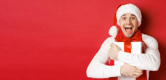 概念冬天假期圣诞节生活方式特写镜头快乐男人。圣诞老人他接收现在快乐拥抱礼物盒子站红色的背景