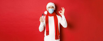 概念科维德圣诞节假期流感大流行快乐的男人。庆祝一年医疗面具圣诞老人他推荐手洗手液显示标志眨眼