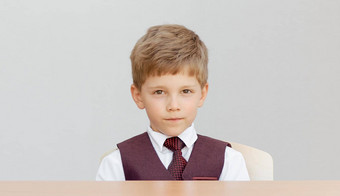 男孩坐在桌子上背心领带