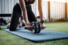 初学者女人锻炼健身锻炼腹部双轮锻炼健身房地面健康的现代人概念