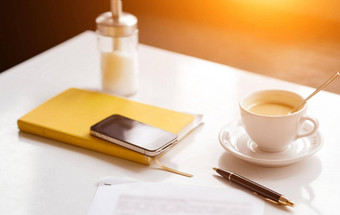 白色表格黄色的记事本电话杯咖啡笔表纸模糊的面团