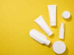 Jar瓶空白色塑料管化妆品黄色的背景包装奶油过来这里血清广告产品促销活动