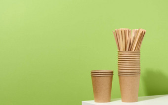 棕色（的）纸纸板杯木激动人心的棒白色表格绿色背景环保餐具