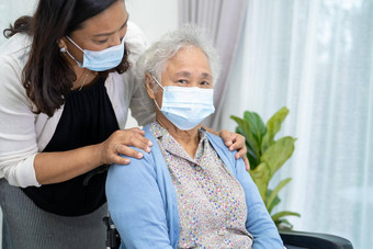 照顾者亚洲高级上了年纪的夫人女人坐着轮椅穿脸面具保护安全感染科维德冠状病毒