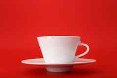 关闭白色陶瓷咖啡茶杯飞碟孤立的明亮的红色的背景复制空间