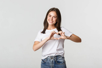 温柔的美丽的浅黑肤色的女人女孩显示心手势表达爱护理