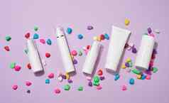 Jar瓶空白色塑料管化妆品紫色的背景包装奶油过来这里血清广告产品促销活动