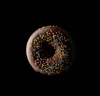 巧克力甜甜圈五彩缤纷的洒悬浮黑色的背景