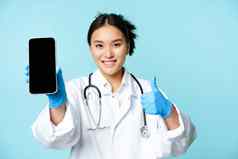 网络医疗保健在线概念微笑亚洲女医生护士显示智能手机屏幕应用程序接口拇指推荐网站