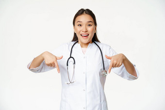 热情的医疗工作人员亚洲女医疗保健工人指出手指微笑惊讶显示折扣出售诊所白色背景