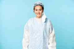 肖像微笑亚洲女医生护士穿个人保护设备快乐站蓝色的背景