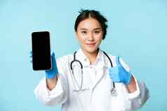 网络医疗保健在线概念自信亚洲女医生护士显示智能手机屏幕应用程序接口拇指推荐网站