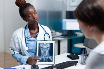 非洲美国放射科医生医生持有平板电脑电脑显示骨头放射学
