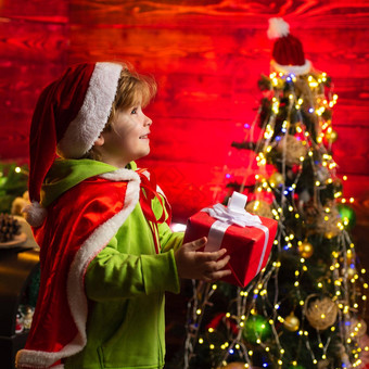 快乐圣诞节快乐一年男孩圣诞节礼物漂亮的蹒跚学步的男孩圣诞节圣诞老人他持有礼物盒子美丽的奢侈品装饰背景