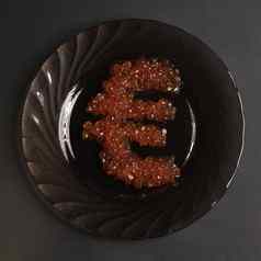 欧元象征使红色的鱼子酱黑色的板灰色的背景食物世界精英餐厅象征钱