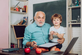 友好的孩子男孩成熟的老师教室黑板上桌子上祖父会说话的孙子世界老师一天教育过程