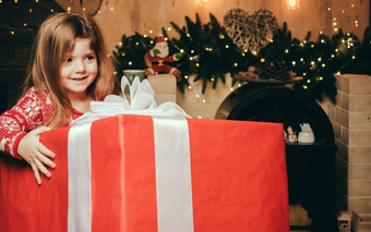 快乐的微笑快乐可爱的女孩持有巨大的礼物现在圣诞老人圣诞节夏娃魔法概念明亮的年室内概念给接收礼物