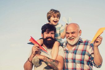 周末家庭玩但年龄休闲活动孩子飞行员玩具喷气背包天空背景父亲儿子祖父玩家庭时间