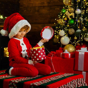 快乐明亮的圣诞节可爱的婴儿享受圣诞节童年记忆圣诞老人男孩孩子庆祝圣诞节首页家庭假期男孩可爱的孩子快乐的情绪玩圣诞节树