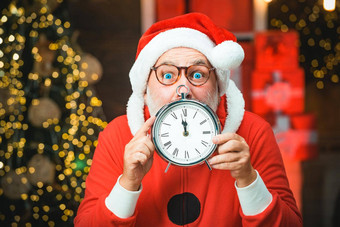 快乐一年圣诞老人老人真正的胡子持有时钟快乐圣诞节圣诞老人时钟照片圣诞老人指出时钟显示分钟午夜