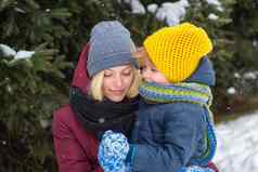 妈妈。儿子享受冬天在户外松树覆盖雪美丽的家庭走冬天雪森林假期圣诞节幸福童年爱