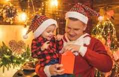 微笑父亲儿子圣诞老人的他开放圣诞节礼物现在盒子一年树火的地方背景圣诞节时间童年记忆圣诞节孩子梦想