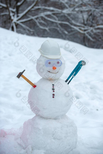雪人工人锤雪背景有趣的雪人工作头盔雪场手工制作的雪人雪户外