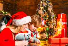 妈妈孩子写作信圣诞老人列表圣诞节礼物圣诞节室内快乐圣诞节快乐一年明亮的年室内概念