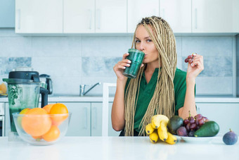 排毒女手持有玻璃新鲜的有机绿色奶昔菠菜健身节食有机食物维生素运动年轻的女人蛋白质摇厨房