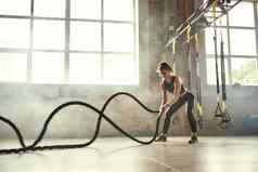 强大的美丽的年轻的运动女人完美的身体参考练习绳子健身房