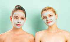 自然美丽的朋友女孩粘土泥面具脸健康的护肤品健康美概念关闭肖像朋友孤立的苍白的蓝色的背景