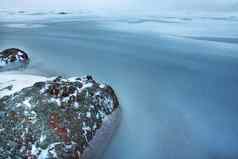 灰色的石头红色的斑点海岸冻湾冬天