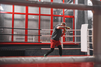 硬工作拳击环肌肉发达的纹身拳击手体育服装冲红色的环锻炼健身房