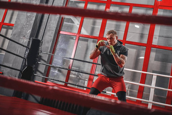 培训肌肉发达的纹身拳击手体育服装冲红色的拳击环锻炼健身房