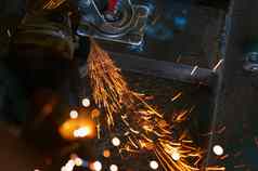 工业工人角磨床切割金属工人工作角磨床橙色火花工具减少磨钢安全工业工作场所金属工厂行业