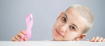 年轻的女人粉红色的丝带白色背景乳腺癌症