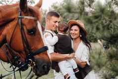 家庭白色衣服儿子站美丽的马自然时尚的夫妇孩子拍摄马