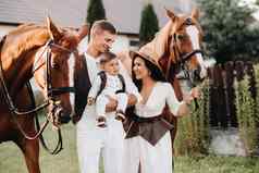 家庭白色衣服儿子站美丽的马自然时尚的夫妇孩子拍摄马