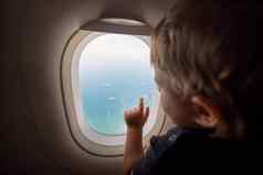 恢复航班开放边界概念小孩子海洋窗口飞行飞机飞行假期幸福