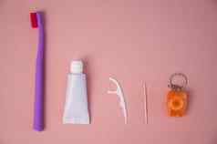 个人口服卫生产品粉红色的背景牙刷管牙膏牙签牙线平躺
