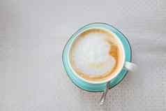 热咖啡卡布奇诺咖啡拿铁艺术玉颜色杯孤立的米色表格卡布奇诺咖啡咖啡杯前视图拿铁艺术乳白色的泡沫热意大利激励饮料服务绿色陶瓷杯子