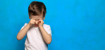 男孩蓝色的背景按摩眼睛眼睛健康眼睛疾病哭婴儿乏力孩子们心理学