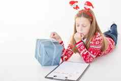 亲爱的圣诞老人信写孩子圣诞节集中孩子涉及到过程思考祝愿欲望漂亮的女孩持有剪贴板纸礼物盒子